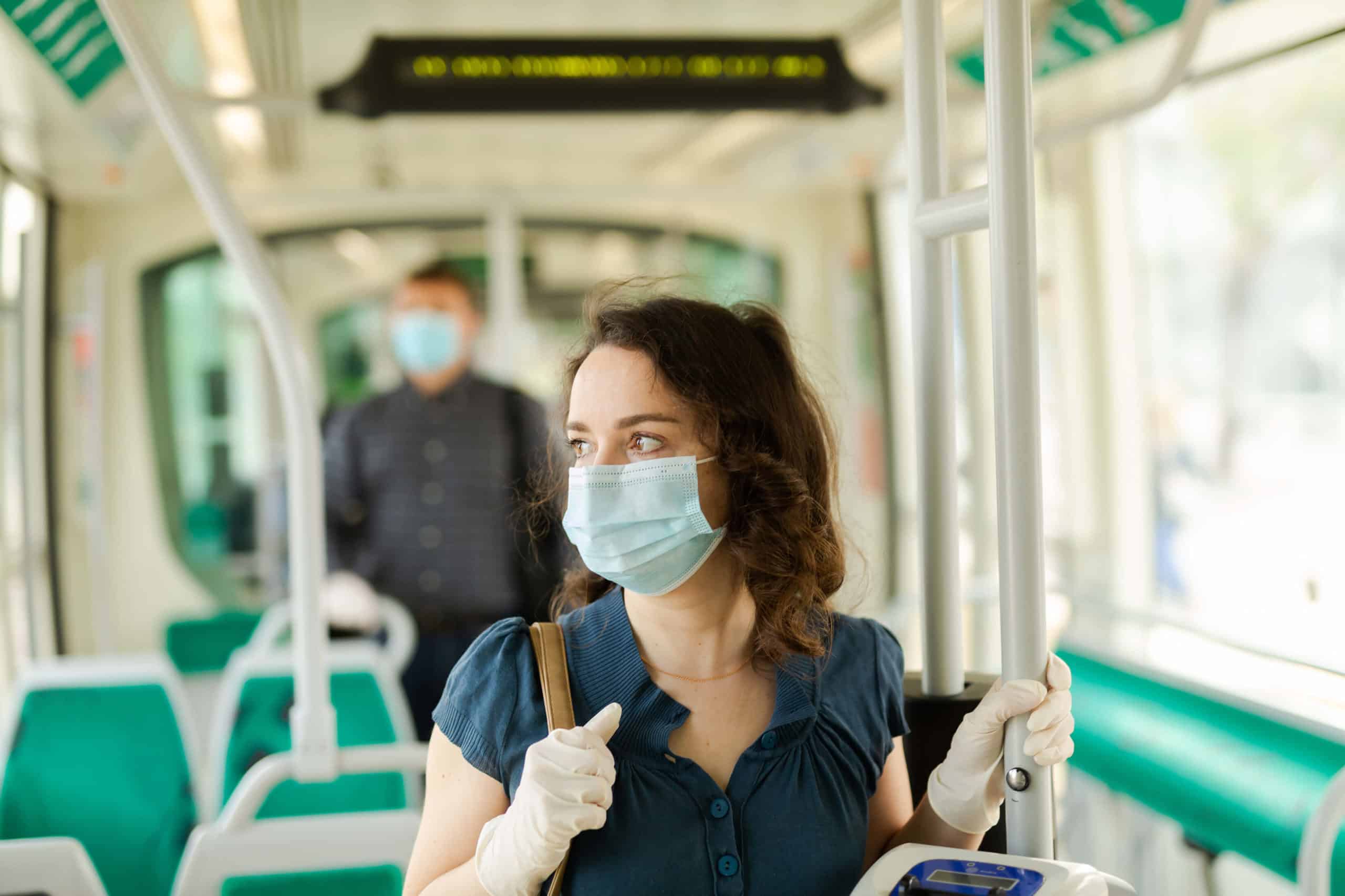 Masked woman riding train