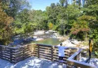 A woman overlooks the water from the trail.