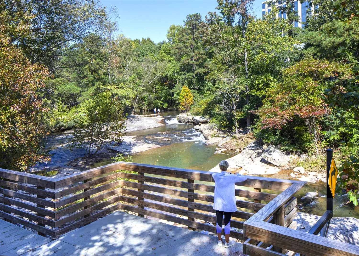 A woman overlooks the water from the trail.