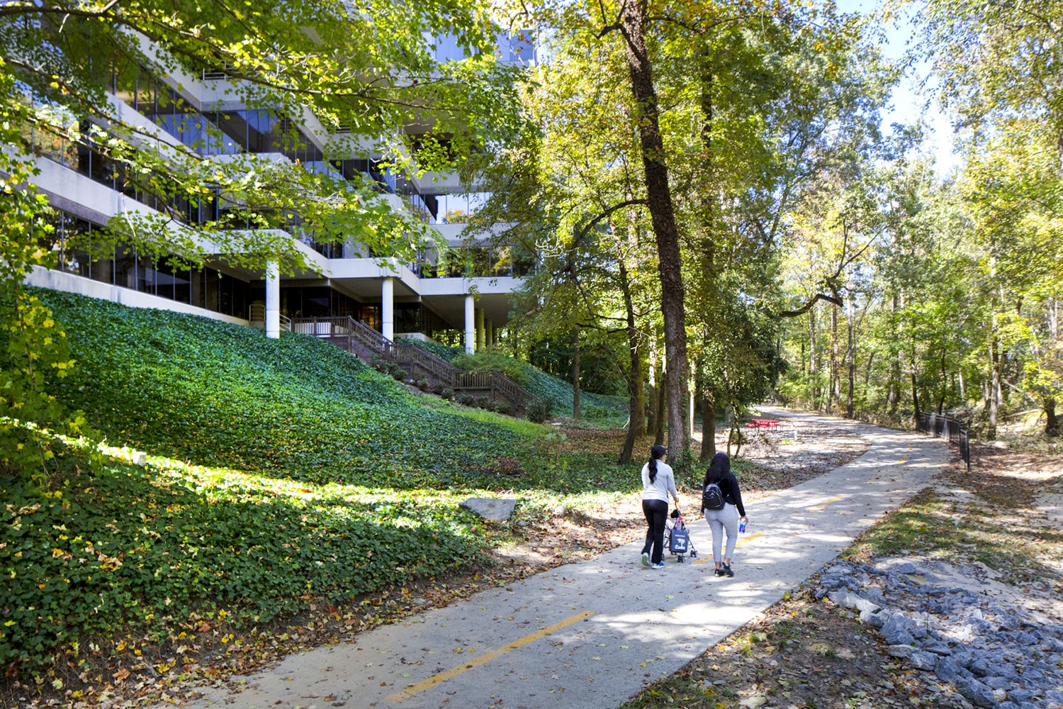 A family walks the trail that is behind an office building.