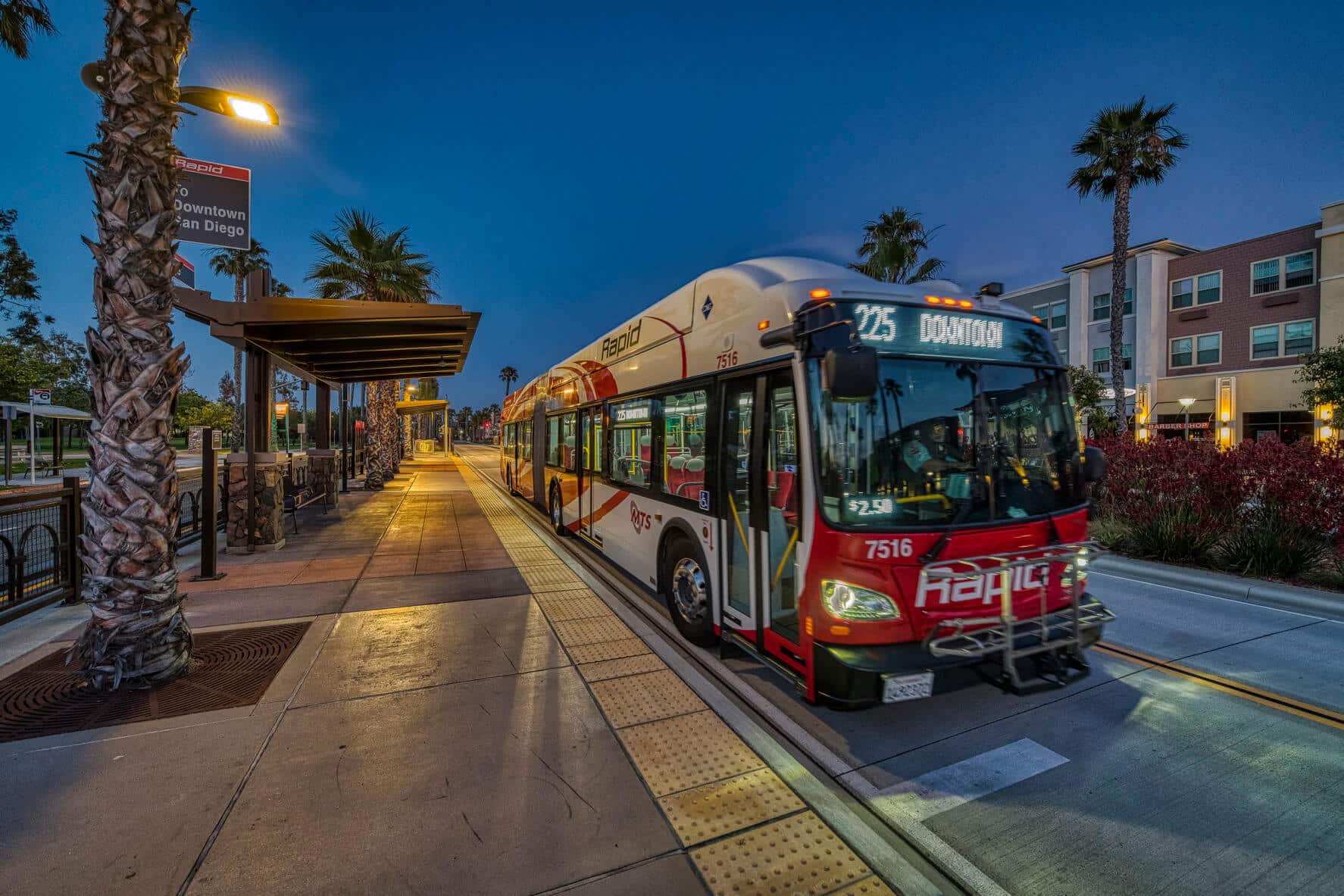 A rapid bust picks is parked at a bus station on the side of the road