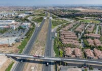 An aerial view of a Rapid bus drives across a bridge over a highway.