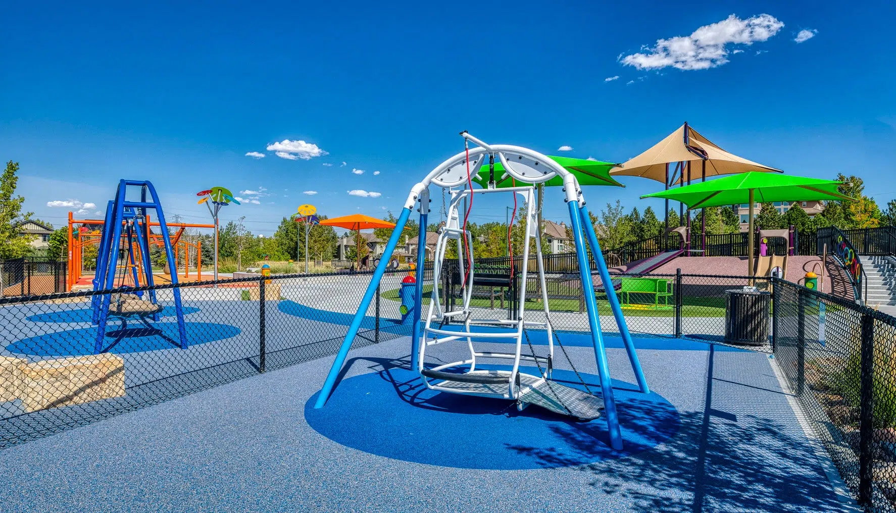 A swing in an inclusive playground made to completely strap someone into it creating a safe swing