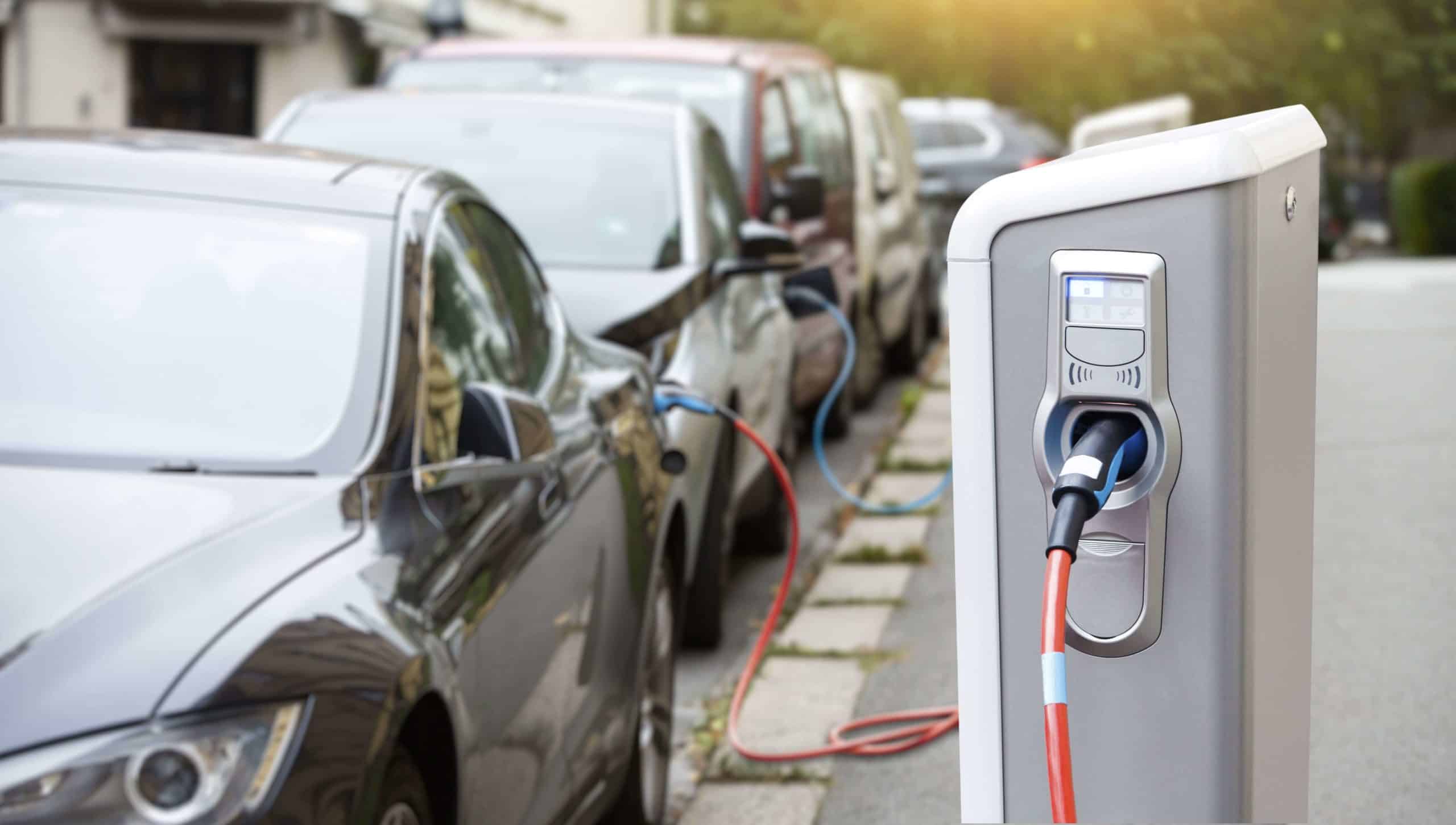 Cars parked along a road charing their electric cars
