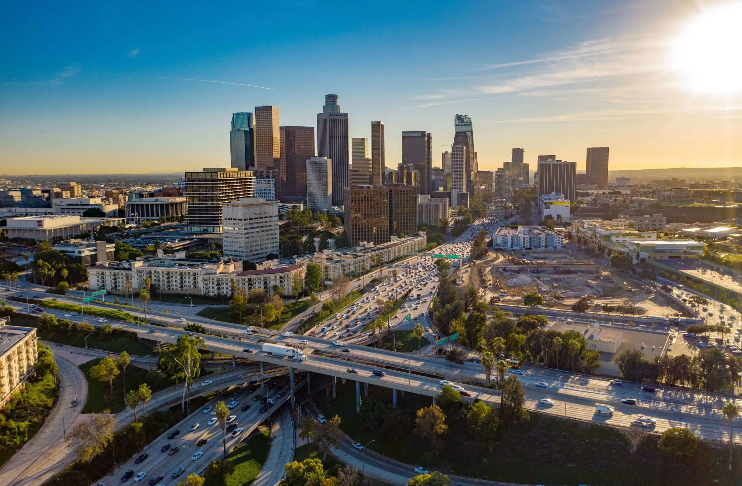 A skyline in California with a busy highway stretched in front of it showing traffic.