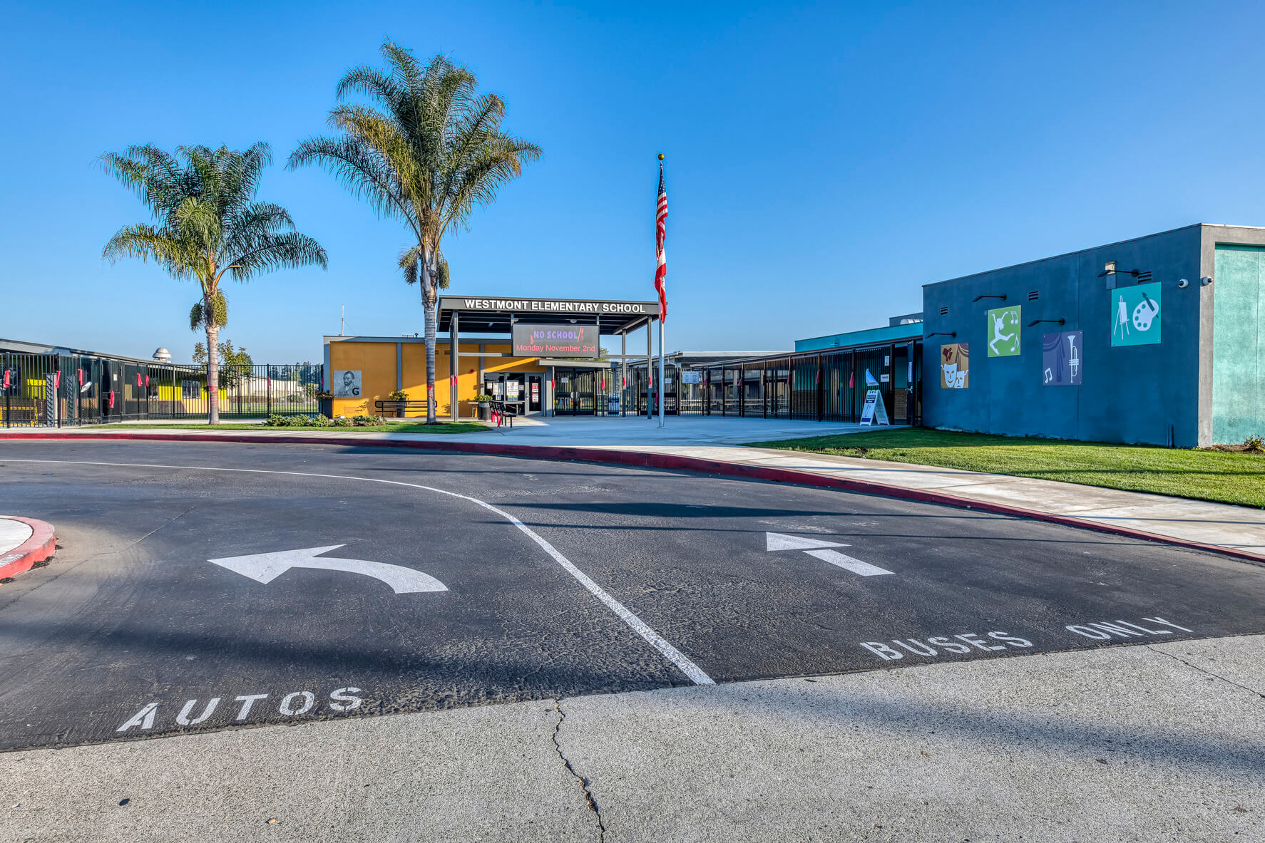 An automobile and bus entrance from the main street into the school parking lot